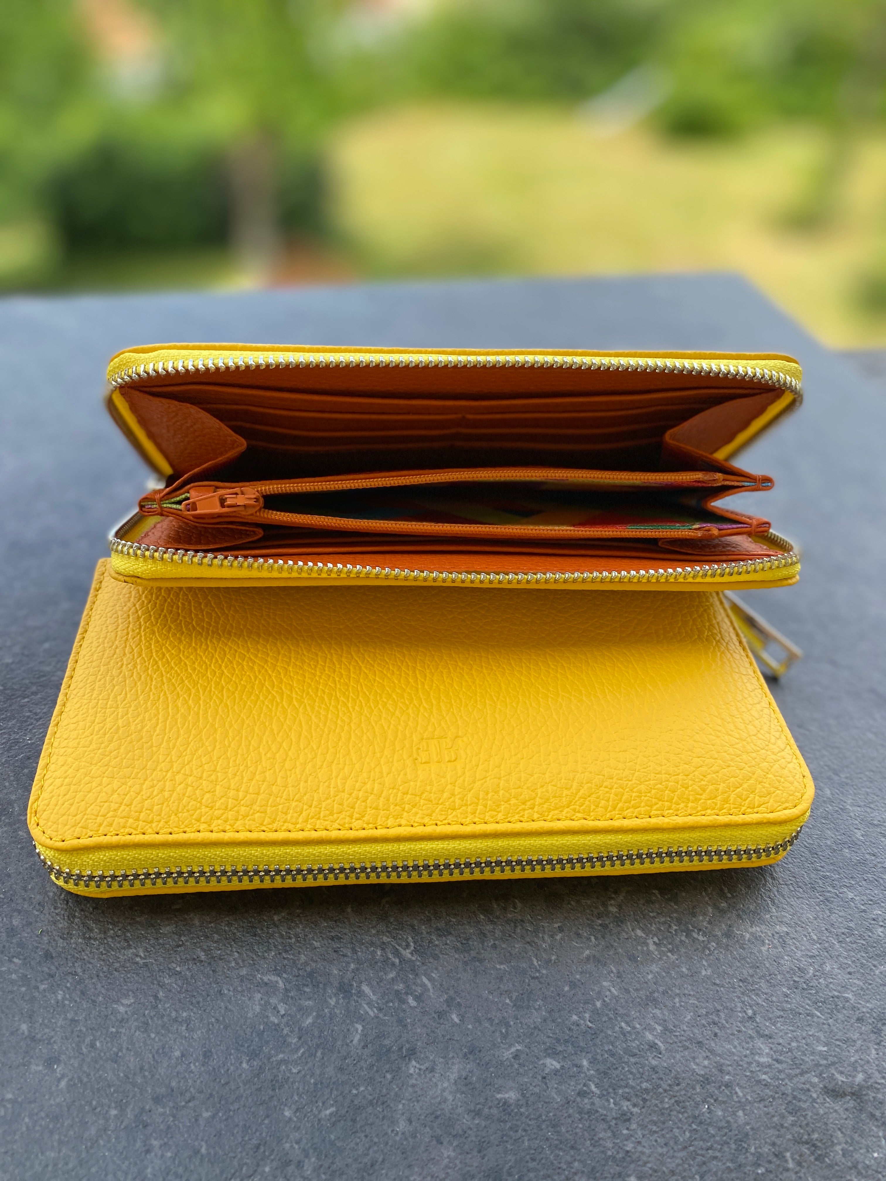 Yellow wallet on a dark surface with a blurred green background