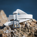 White belt with a silver buckle on a rocky surface