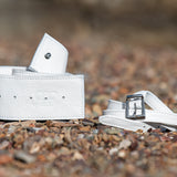 White belt with a buckle on a gravel surface