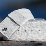 White leather wallet on a textured surface with a blurred blue background