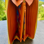 Open orange wallet with colorful interior on a gray surface